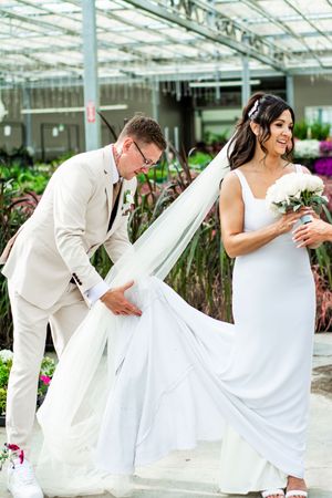 Playful wedding photo sequence in a greenhouse with flowing white dress movements.