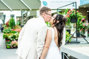 A romantic moment shared between a couple at an outdoor garden venue.