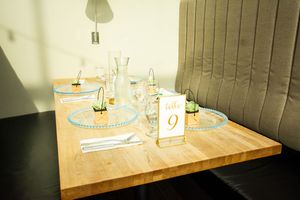 Wedding reception table settings with nautical-themed decor and table numbers.