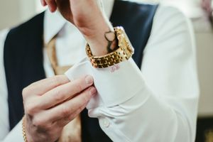 Detail shot of hands adjusting formal wear cufflinks and accessories.