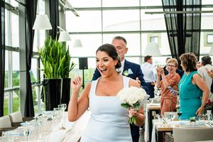 Wedding reception venue with glass walls and tropical greenery decor.