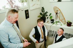 Four candid moments captured during a wedding celebration showing guests and family interacting in an indoor setting.