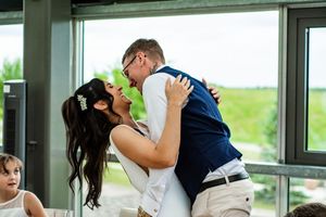 Wedding ceremony participants sharing joyful moments in a bright modern venue.