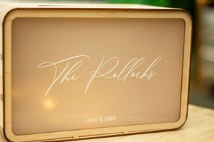 Elegant gold-toned wedding signage displayed in decorative frames.