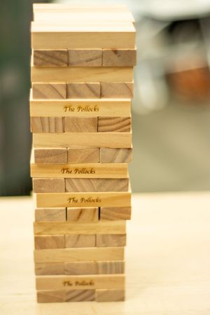 Wooden Jenga blocks stacked neatly with custom text engraved on the sides.