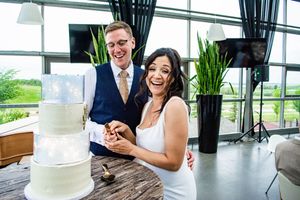 Wedding couple shares an intimate moment during their first dance in an elegant venue with large windows.
