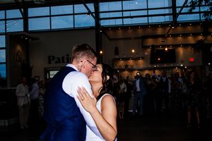 Romantic dance moment at an evening wedding reception under glass ceiling.