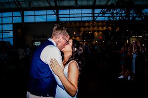 Couples dancing together during an evening wedding celebration in a spacious indoor venue.