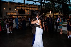 A couple shares their first dance at an indoor wedding reception venue.