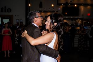 Couples slow dancing together at an evening wedding reception with ambient lighting.