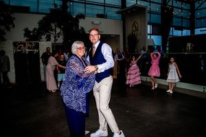 Couples dancing together at an evening reception party with colorful lighting.