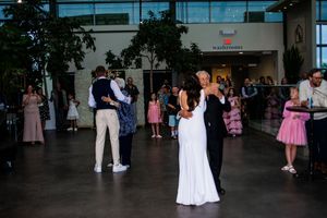 Couples dancing together at a wedding reception in formal attire on a dance floor.