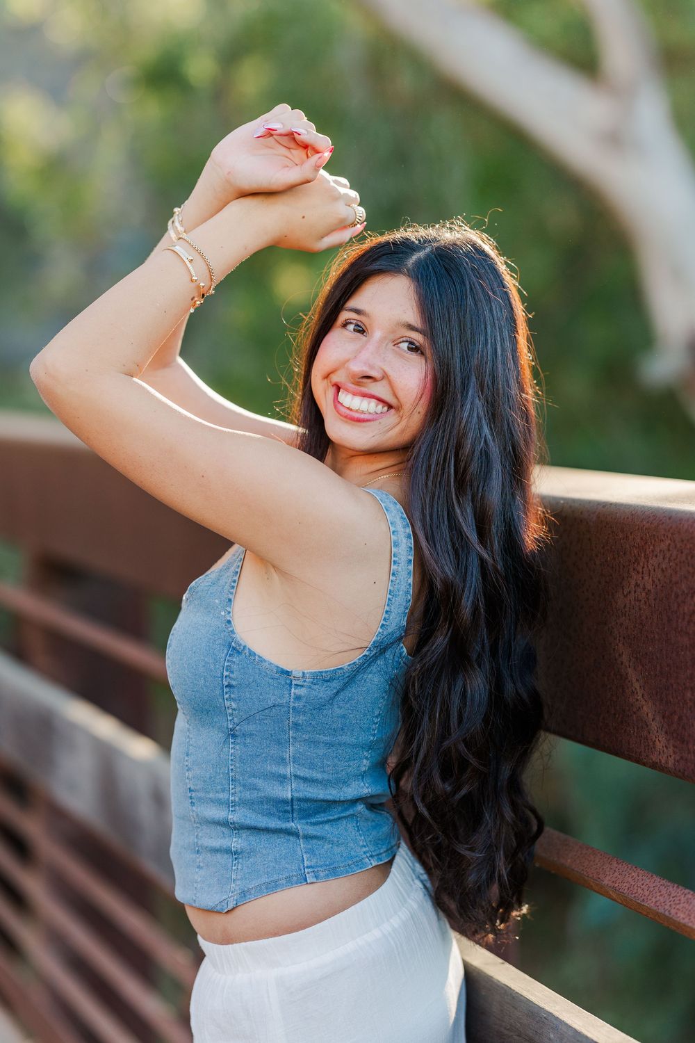 A woman in a denim crop top and white skirt poses playfully outdoors in a series of candid shots.