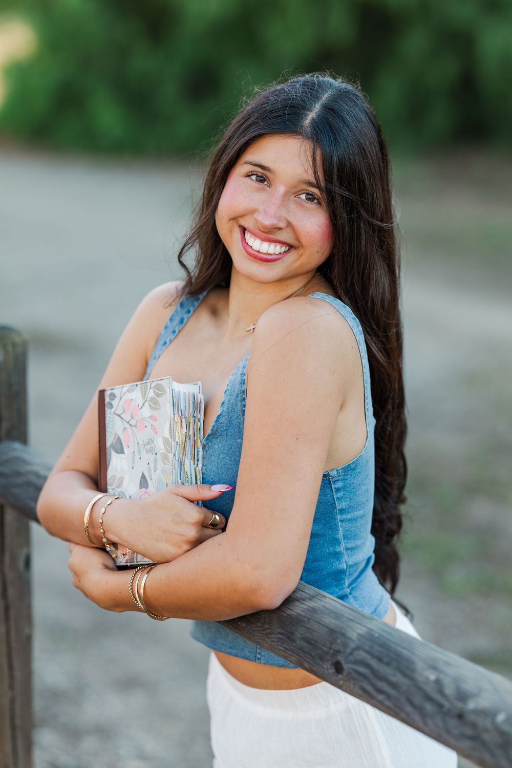 Joyful portrait session leaning against wooden fence in casual denim outfit.