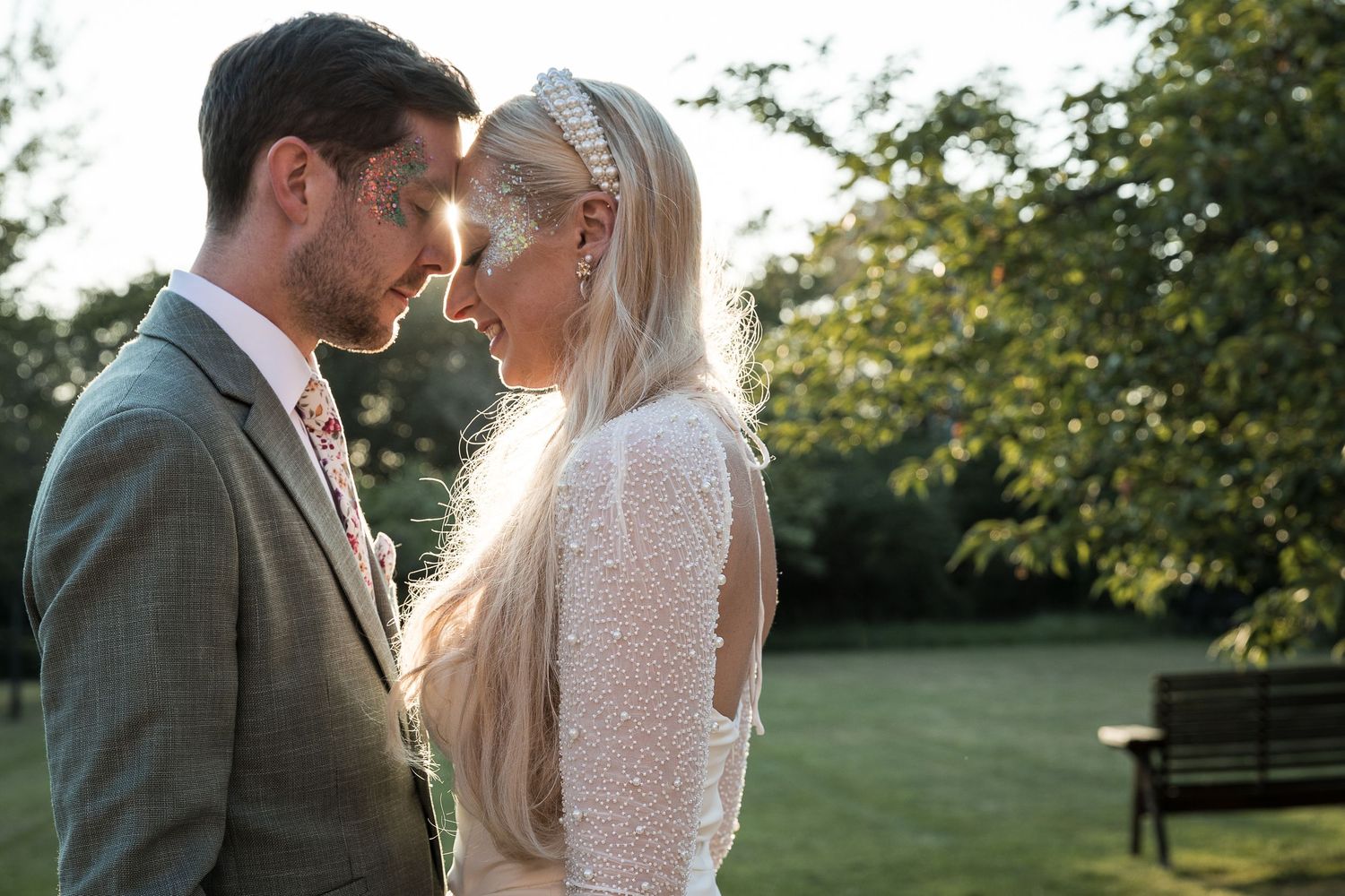 Newlywed couple sharing a tender moment in the Hodsock Priory gardens.