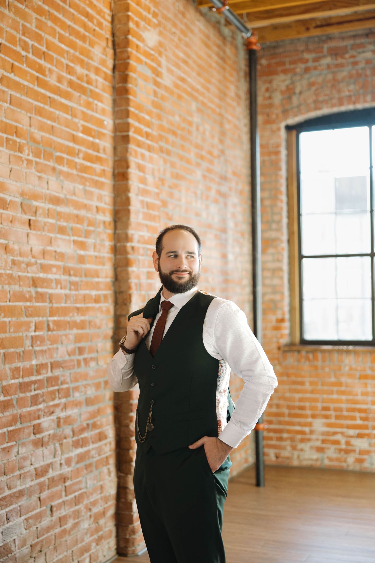 Three views of a person in a black vest and white shirt standing in an industrial brick loft space with natural light.