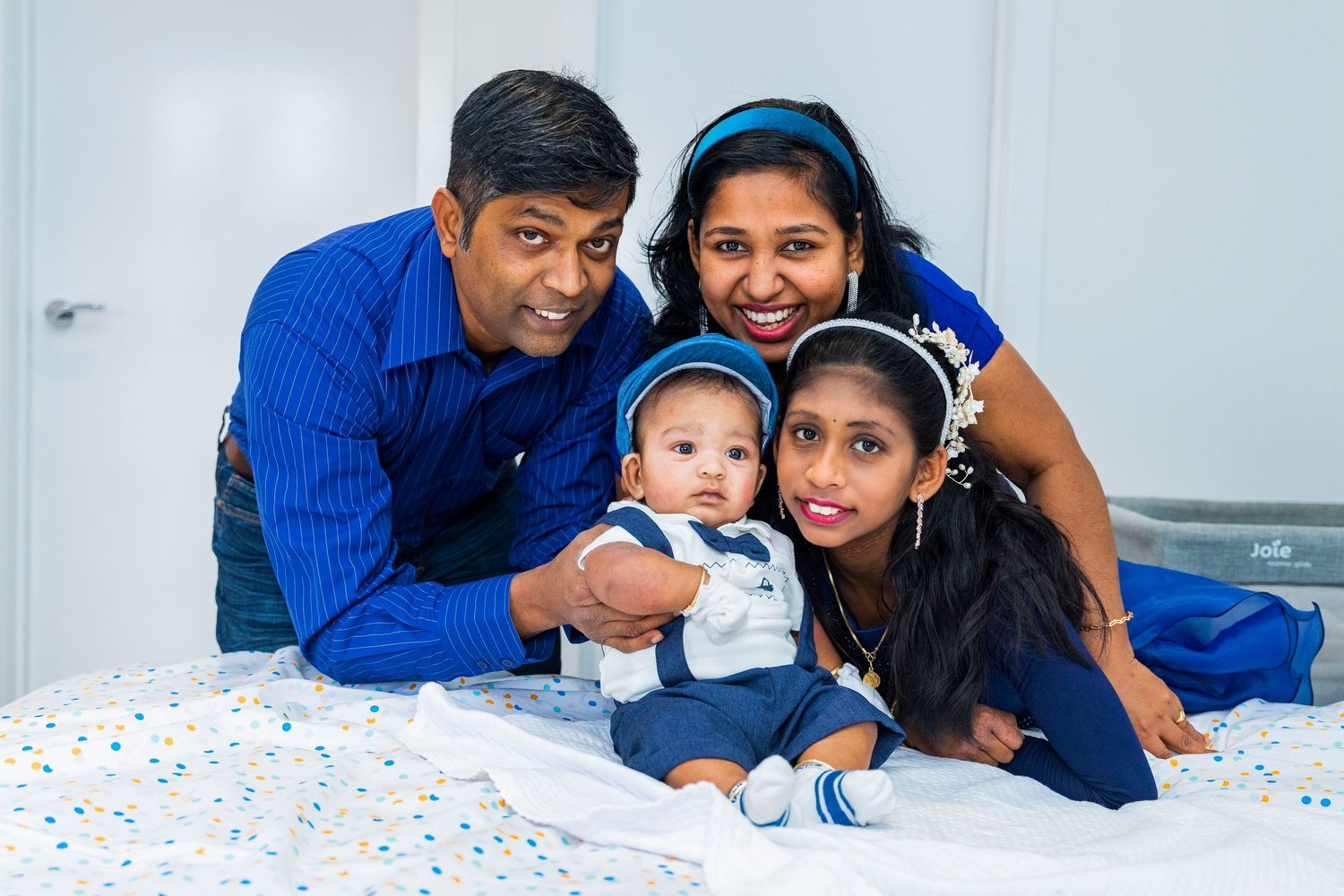 A family shares joyful moments together while relaxing on hanging wicker porch chairs outdoors.