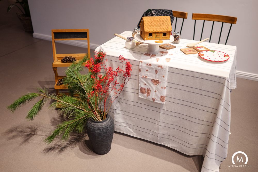 Minimalist interior with wooden chairs, white tablecloth, and potted greenery against neutral walls.