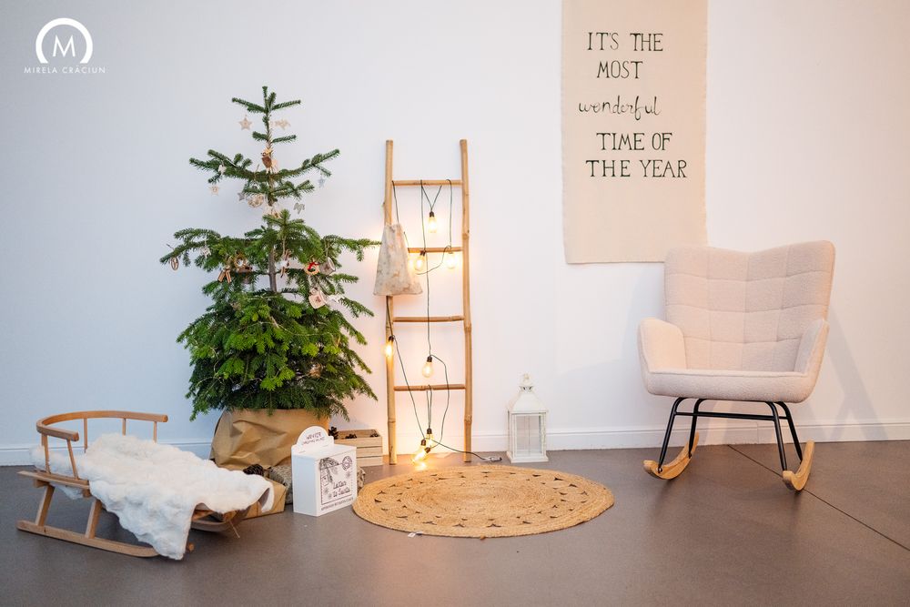 Minimalist holiday decor featuring small Christmas trees, paper decorations, and soft lighting in a clean white space.