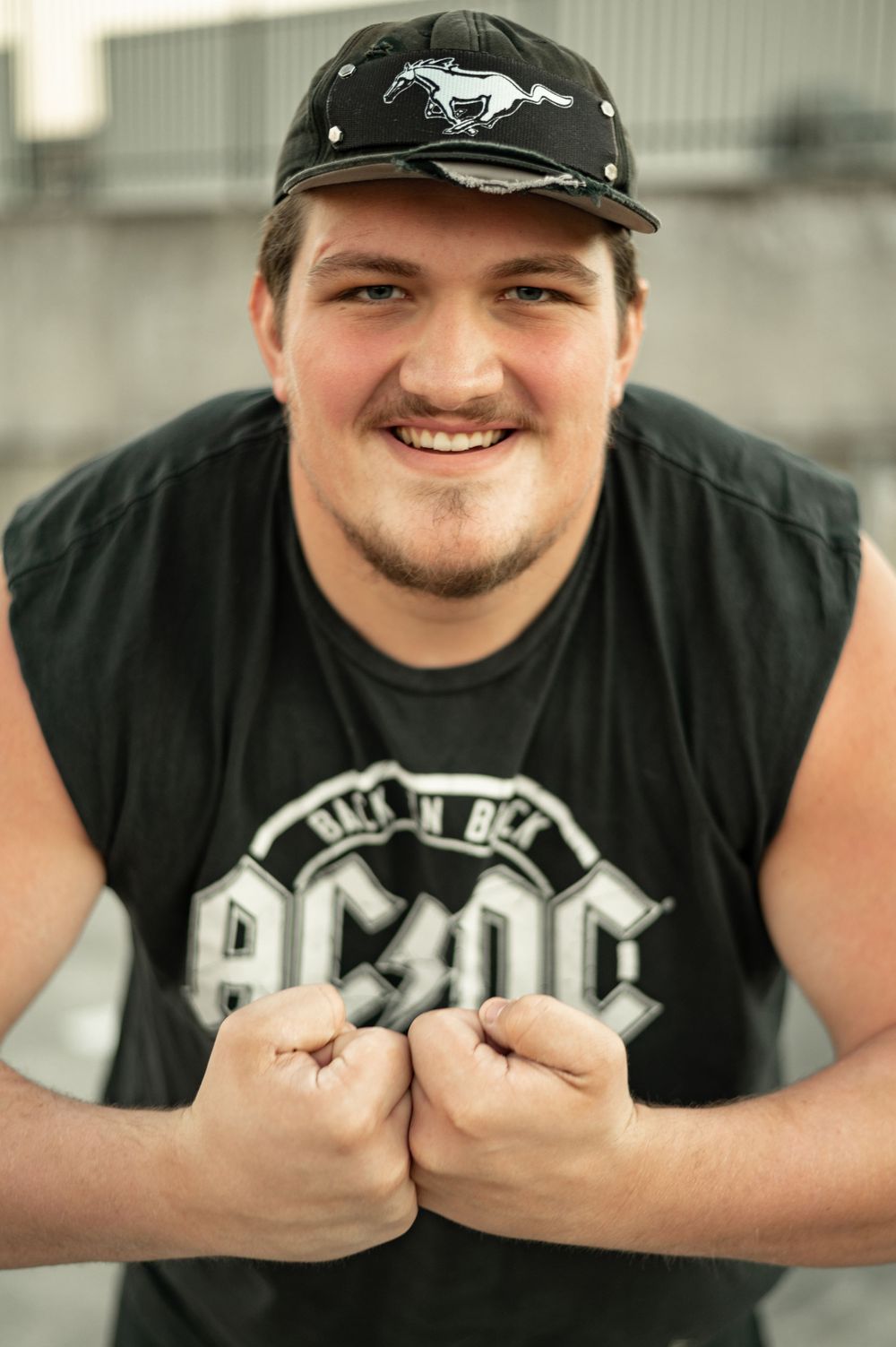 A series of photos showing someone wearing a black t-shirt and baseball cap displaying their ring collection.