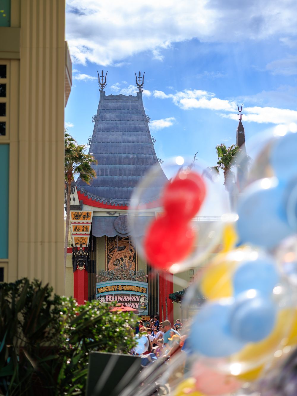 Colorful balloons float in front of the iconic Chinese Theater at Disney's Hollywood Studios theme park.