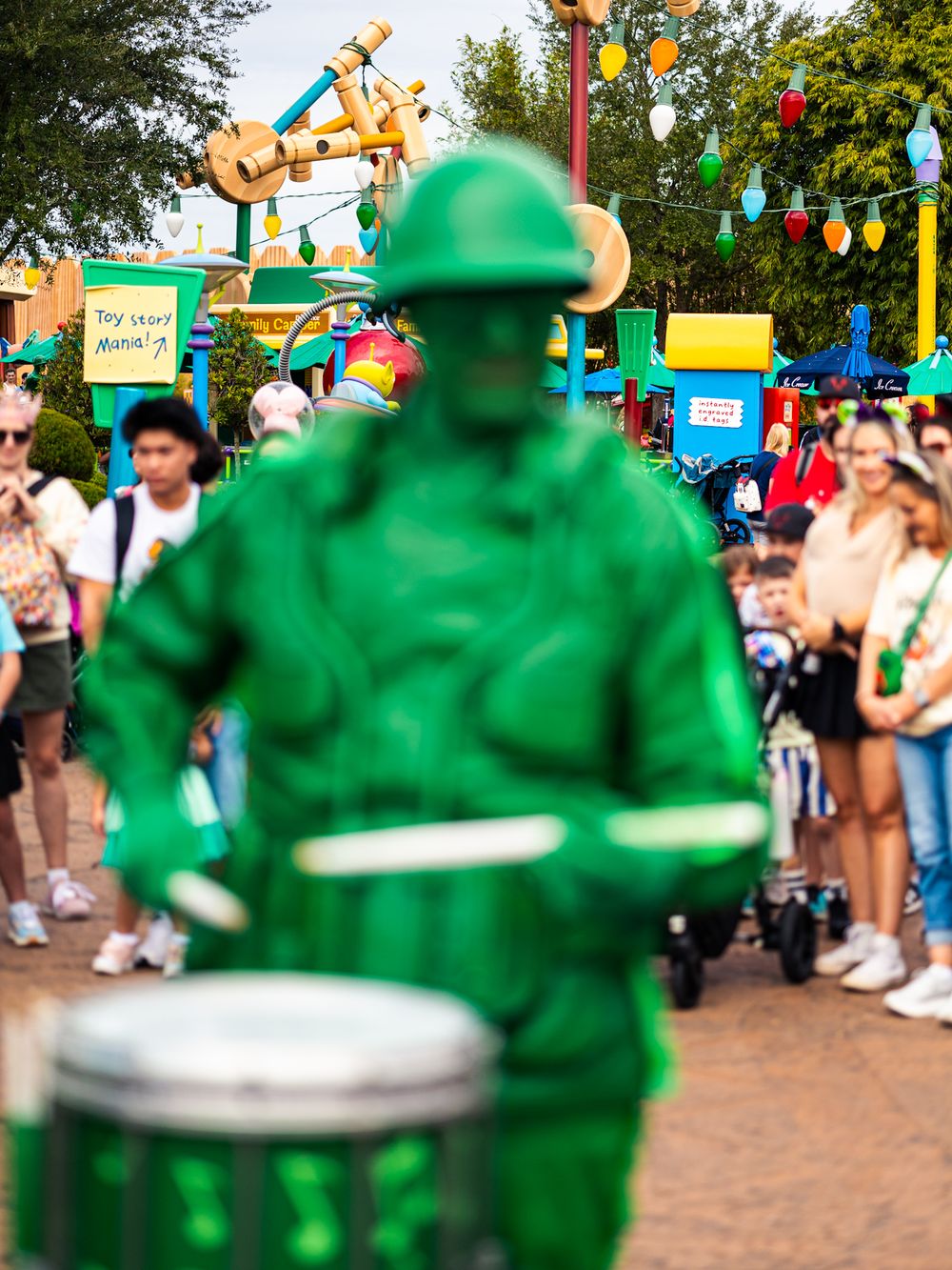 Green army men performers with drums at Disney theme park.