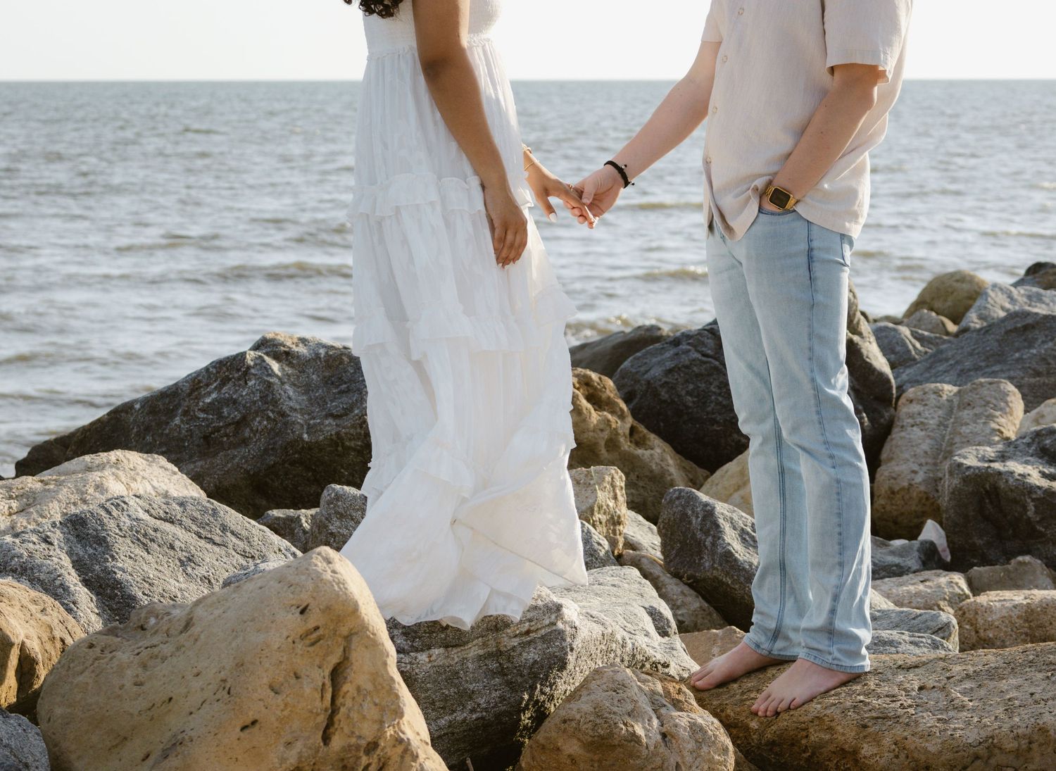 Evening engagement photos on a rocky beach in Florida.