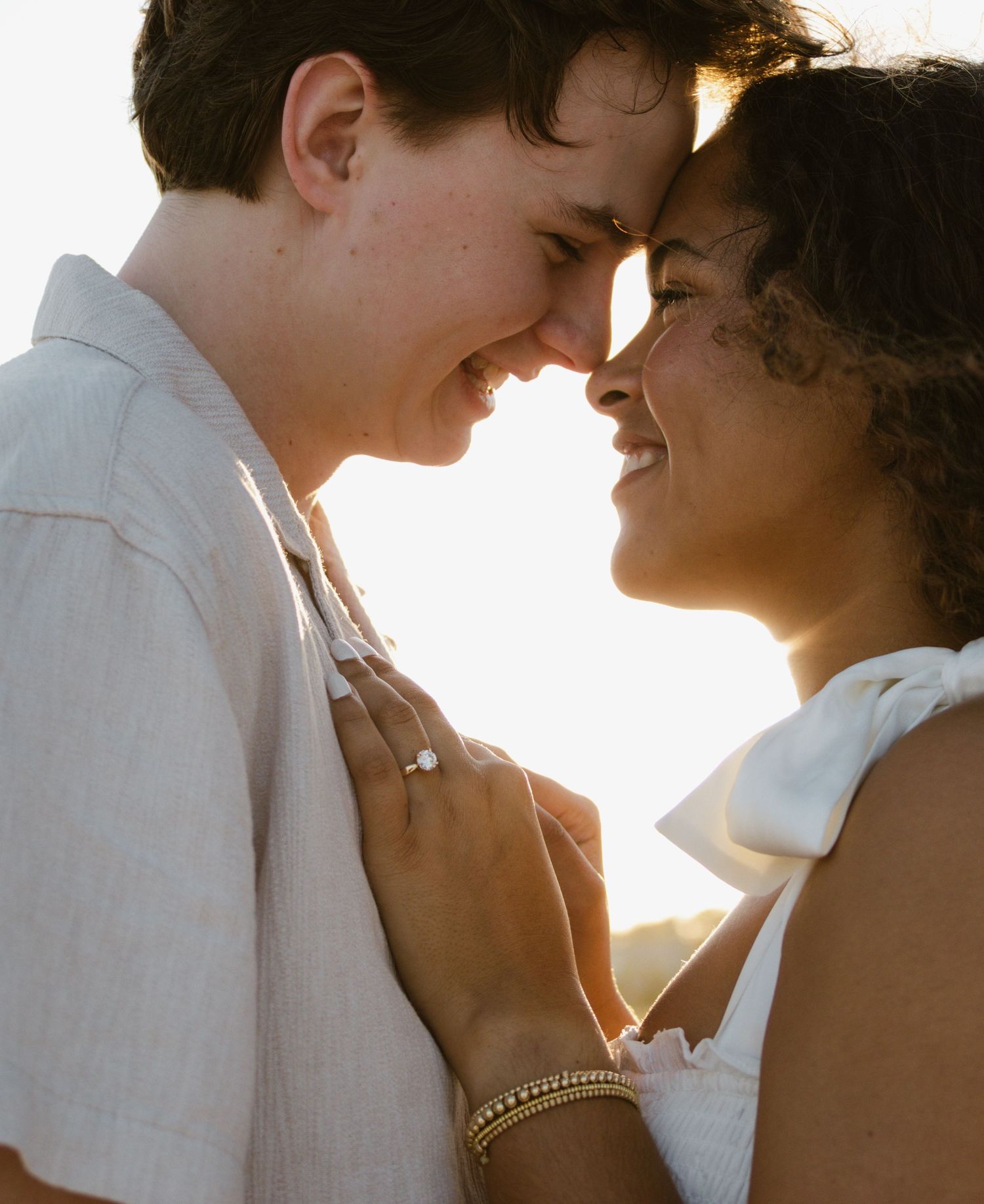 Golden-hour engagement photos on a rocky beach in Florida.