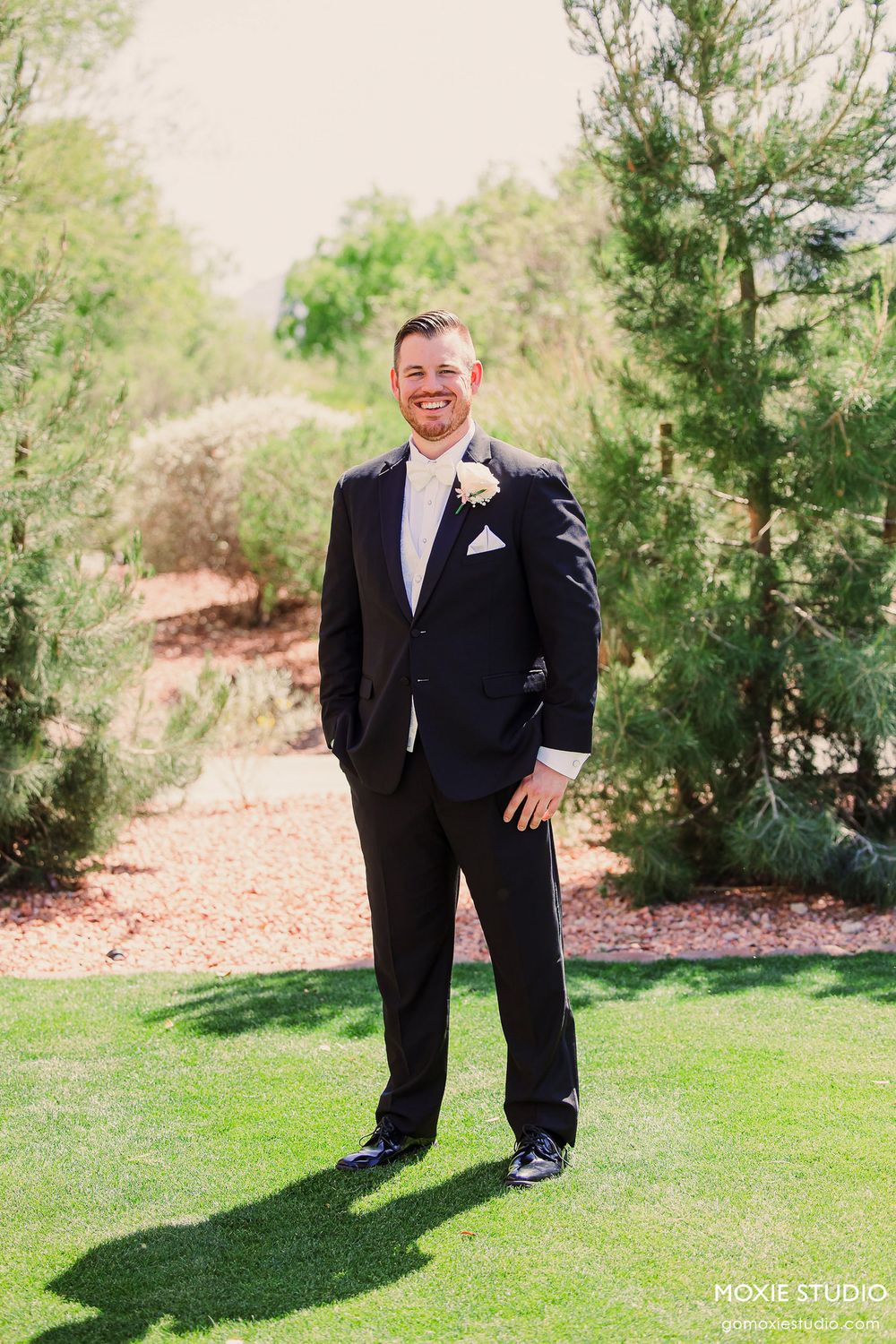 A series of four candid wedding photos showing someone in a black tuxedo posing on green grass with trees in background.
