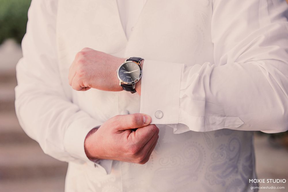 Professional close-up shots of hands adjusting and fastening white dress shirt buttons in sequence.