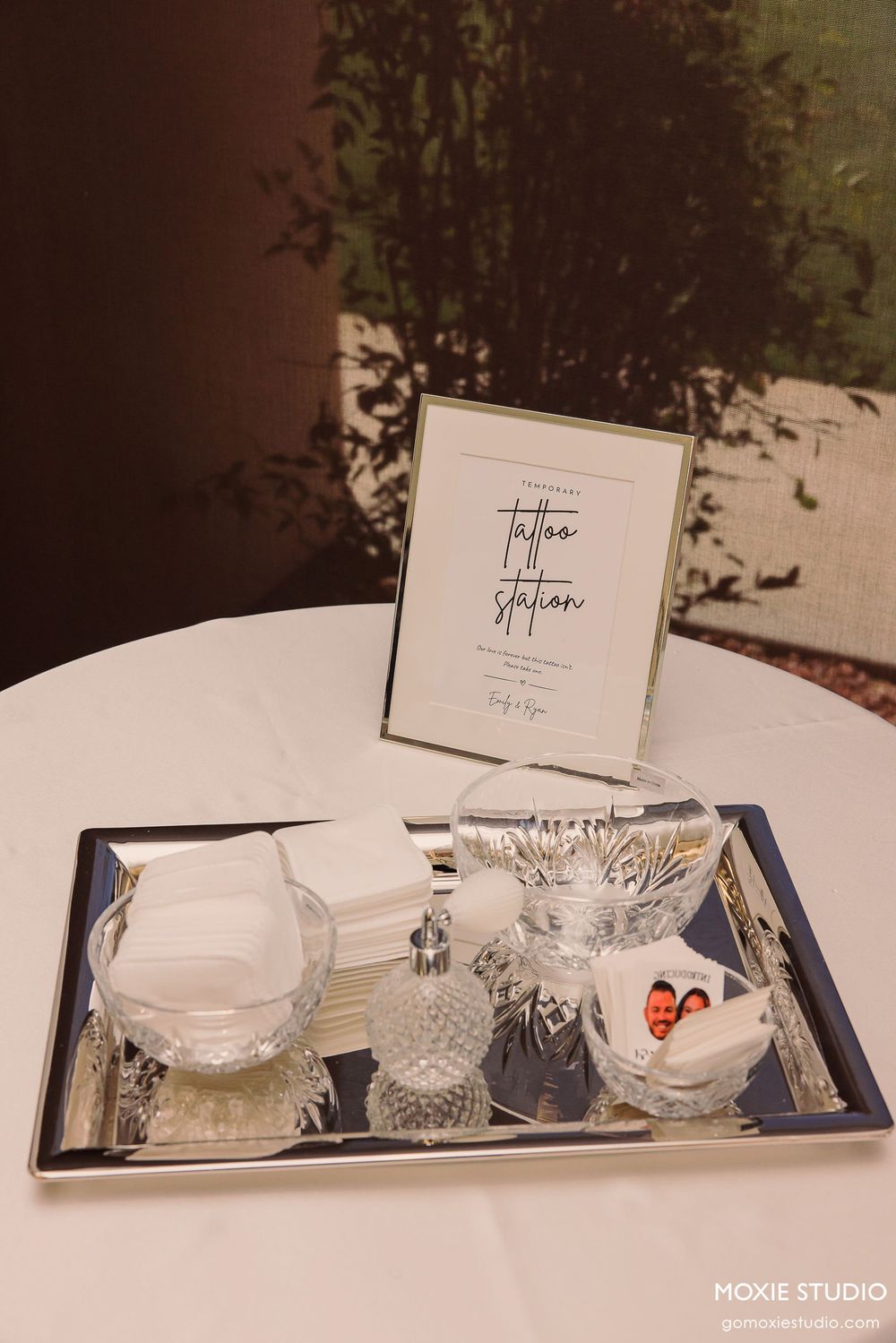 Crystal glassware and white place cards arranged on a navy blue tray for an elegant table setting.