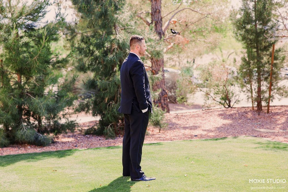Wedding ceremony setup in a scenic outdoor garden setting with evergreen trees in the background.
