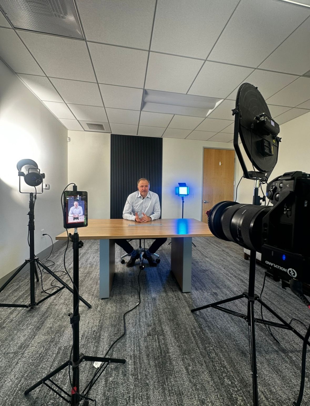 Professional photography studio setup with lighting equipment and white modern furniture in a bright interior space.