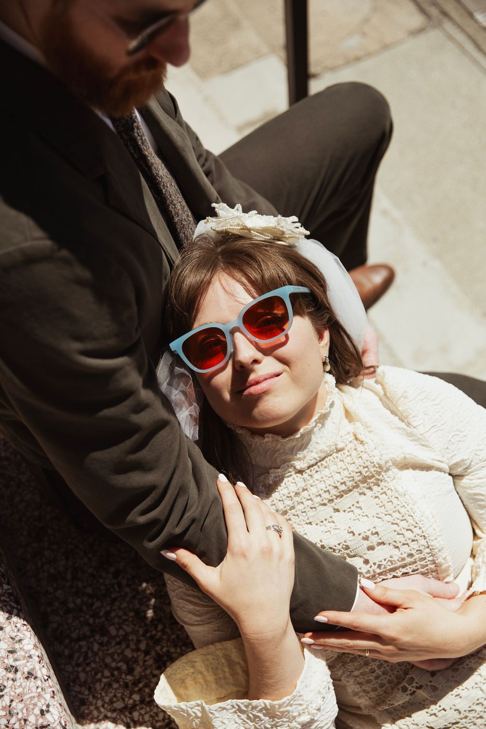 Intimate portrait of couple relaxing on steps with vintage sunglasses.