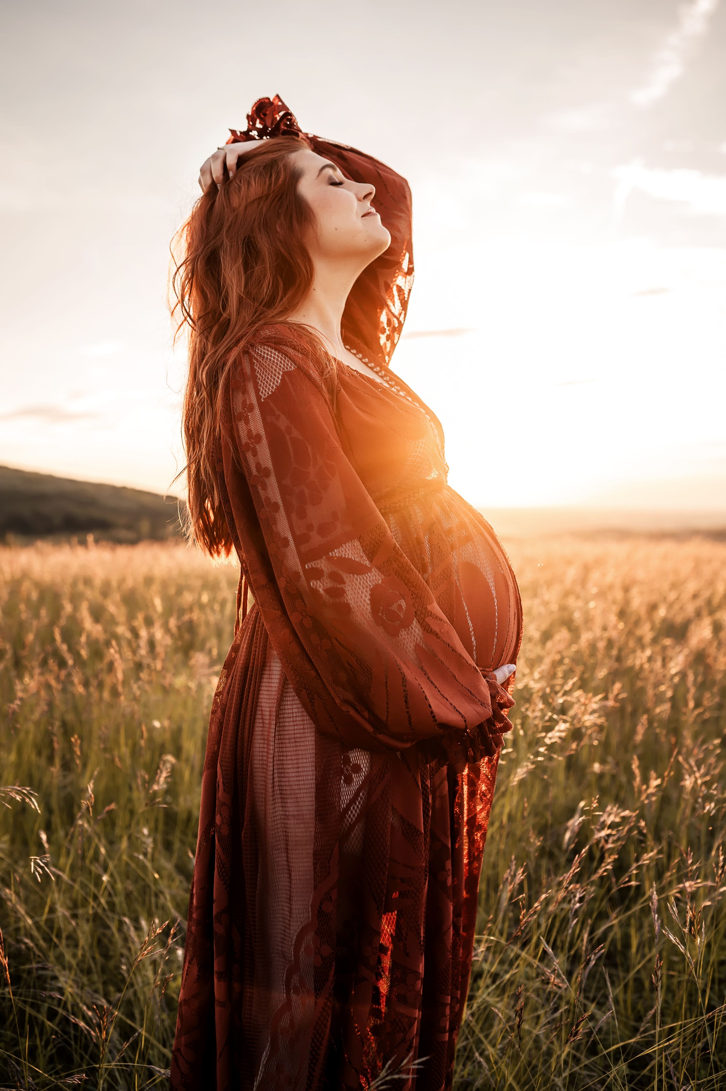 A flowing dress silhouetted against a golden sunset in a serene field of tall grass and wildflowers.