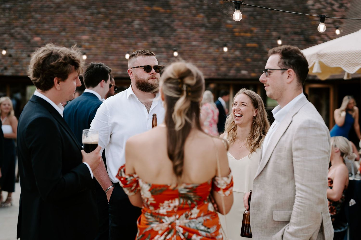 wedding guests enjoying drinks reception at wedding at yardspace old gore in cirencester