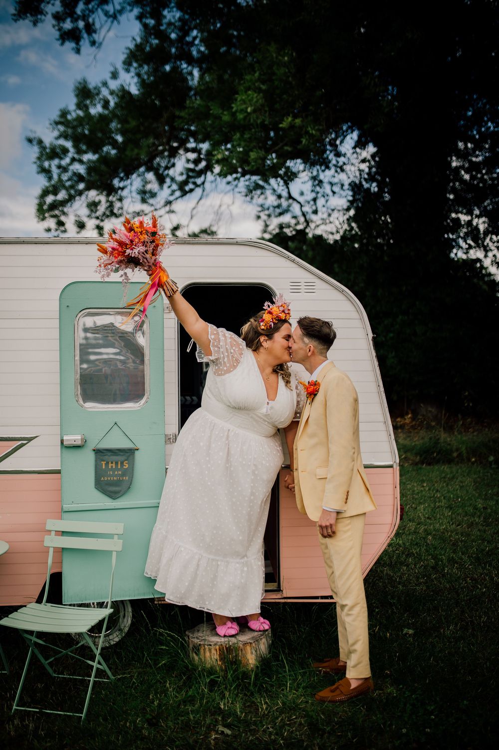 A retro mint green and pink camper trailer serves as a charming wedding photo backdrop. Worcestershire Wedding photographer.