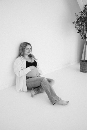 Zwangerschapsshoot in daglichtstudio met natuurlijk licht en zachte kleuren
