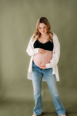 Intieme en liefdevolle zwangerschapsshoot met aanstaande mama in lichte studio