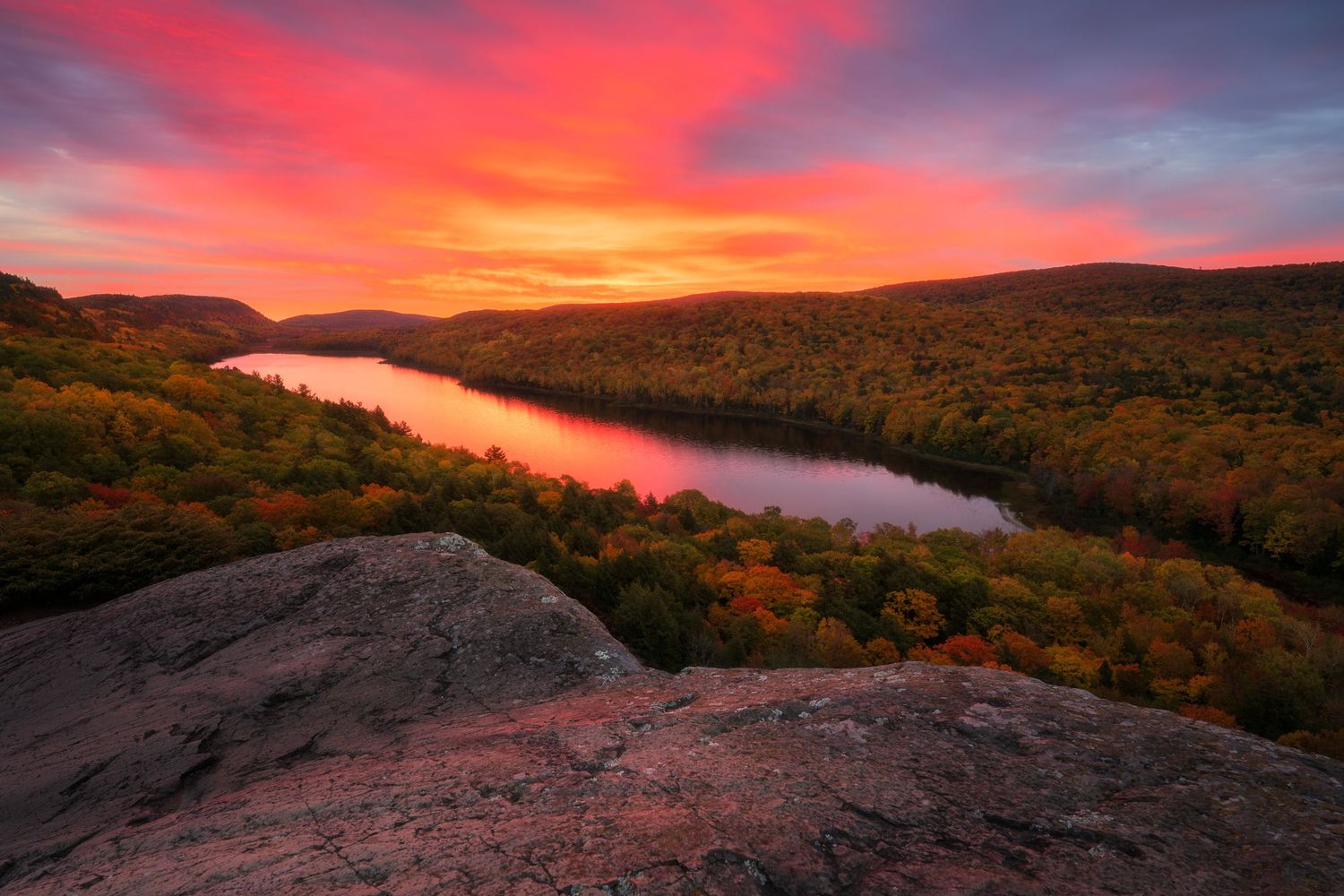 Vibrant sunset illuminates Lake of the Clouds at Porcupine Mountains State Park in Michigan with autumn foliage.