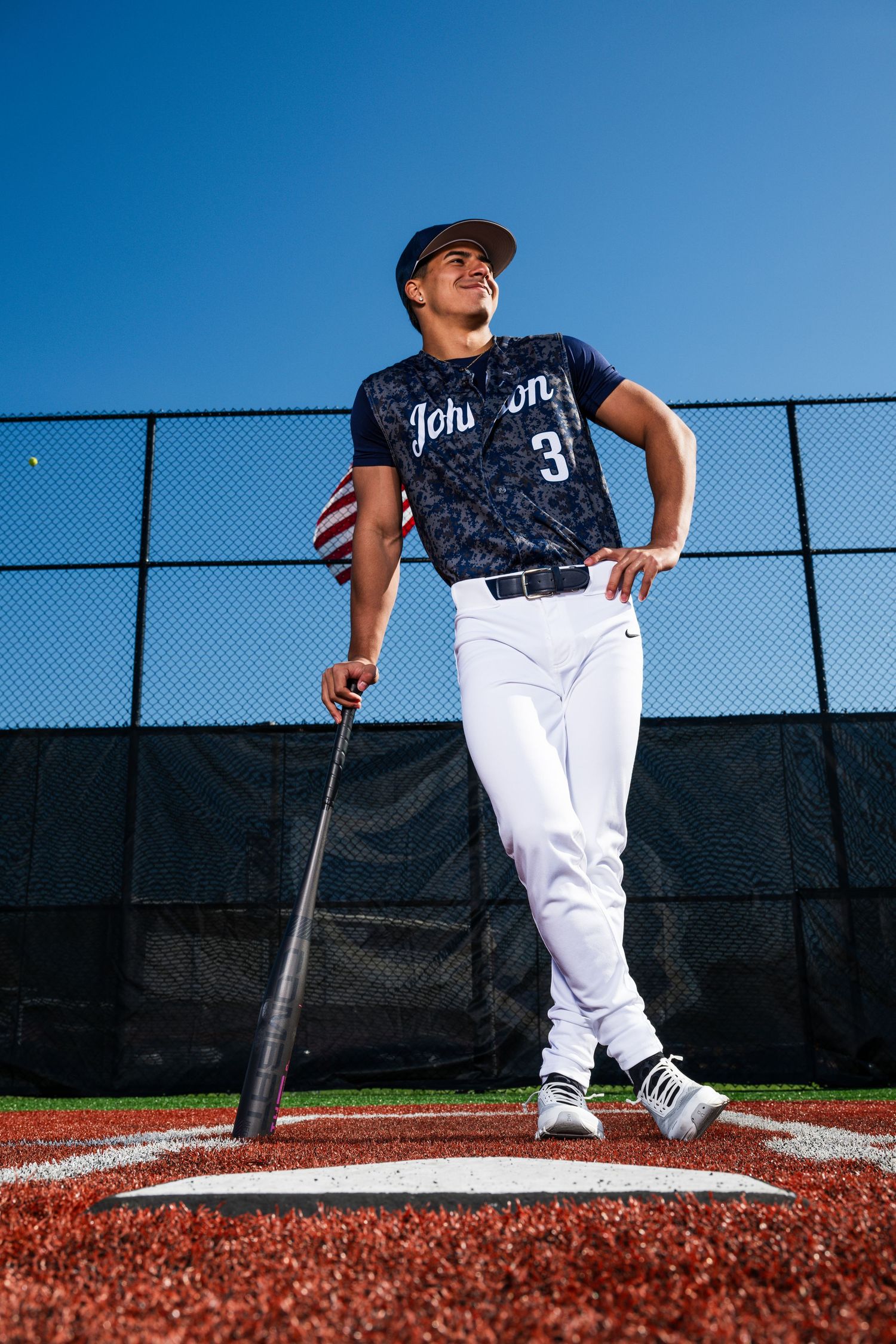 Baseball player #3 in Johnson uniform stands at home plate holding bat under clear blue sky.