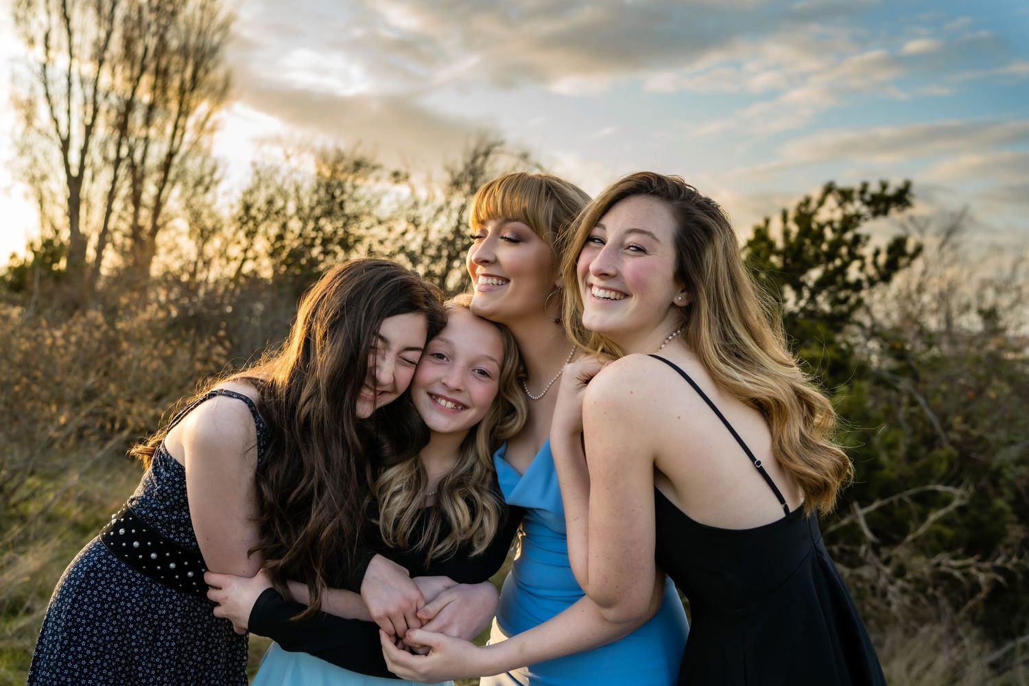 Group of friends sharing joyful moments during sunset photo session.