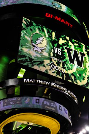 Matthew Knight Arena scoreboard displaying Oregon Ducks vs Washington Huskies basketball game, sponsored by Bi-Mart and Occu.