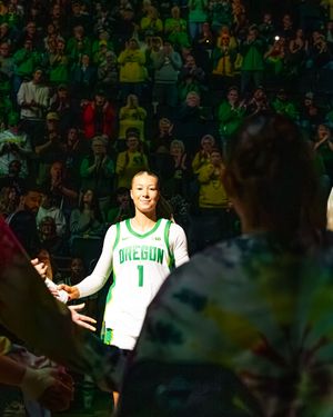 Oregon Ducks player wearing jersey number 1 walks through a tunnel of fans during a basketball game introduction.