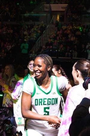 Oregon Ducks women's basketball player #5 smiles during pregame introductions at a packed home arena.