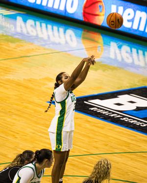Oregon Ducks women's basketball player shoots a jump shot during a Big Ten tournament game on a hardwood court.