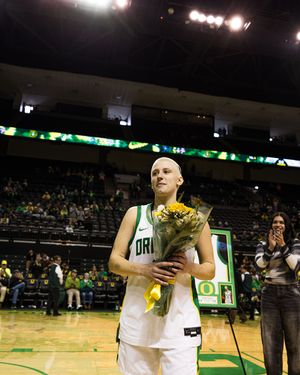 Oregon Ducks women's basketball player holds sunflowers during senior day recognition ceremony at Matthew Knight Arena.
