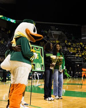 Oregon Ducks mascot hugs player during senior night ceremony at Matthew Knight Arena.
