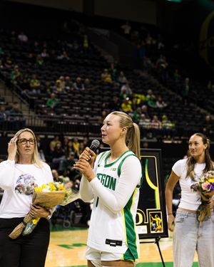 Oregon Ducks women's basketball player speaks at senior night ceremony holding microphone in arena.