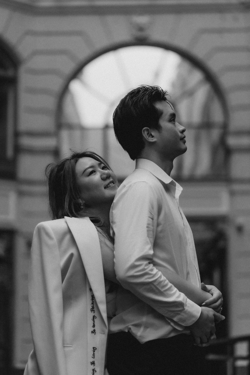 Black and white engagement portrait of a couple standing close together in Helsinki city centre